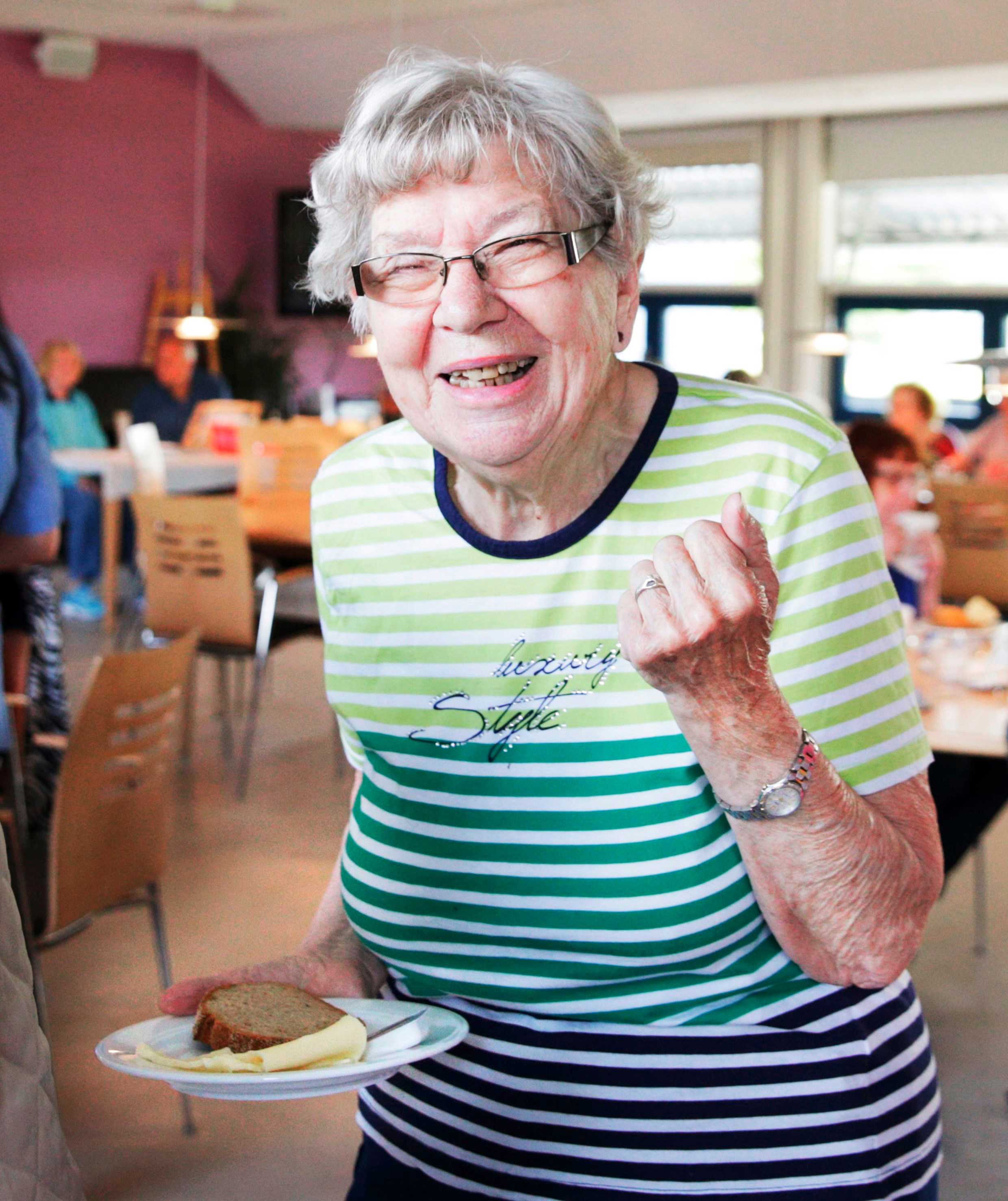 Smilende dame til frokost i aktiviteten på Birkebjergcenteret